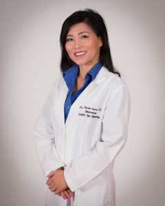 Dr. Nicole Pham Sava, O.D in white laboratory gown