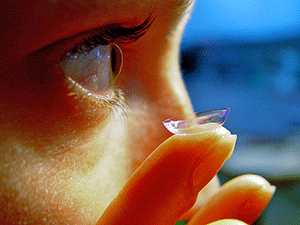 a person holding a contact lens in his hand