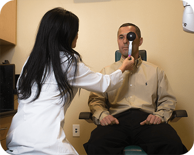 woman doctor checking man's eye