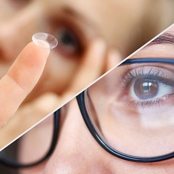 A woman is holding a contact lens in her hand.